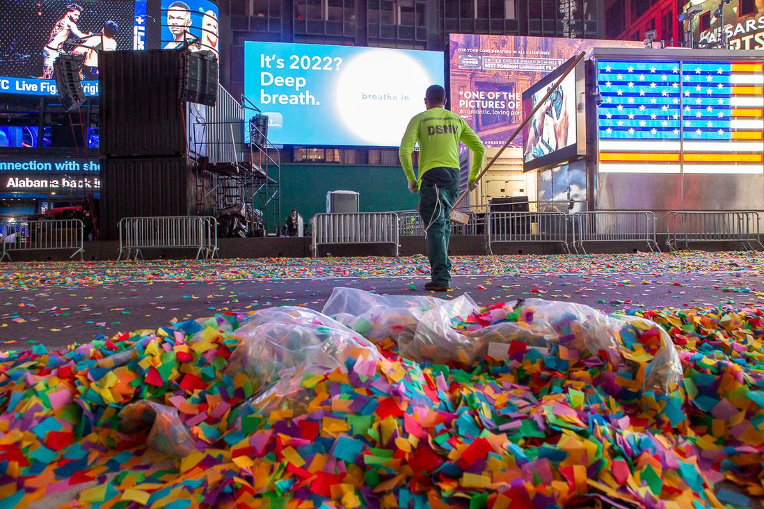 The Department of Sanitation crews cleaning up Times Square after revelers ring in 2022 - workers aided by mechanical sweepers, big collection trucks, and regular brooms.